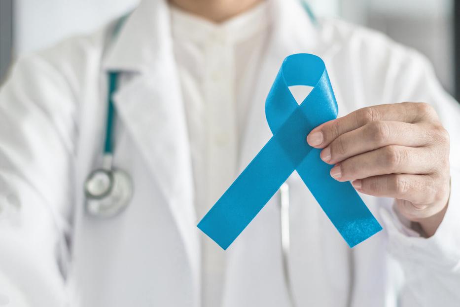 Arzt hält blaue Schleife als Symbol für Prostatkrebsfrüherkennung