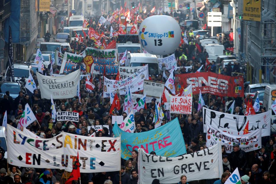 Eine Demonstration mit vielen Menschen, Bannern und Flaggen in einer Stadt.