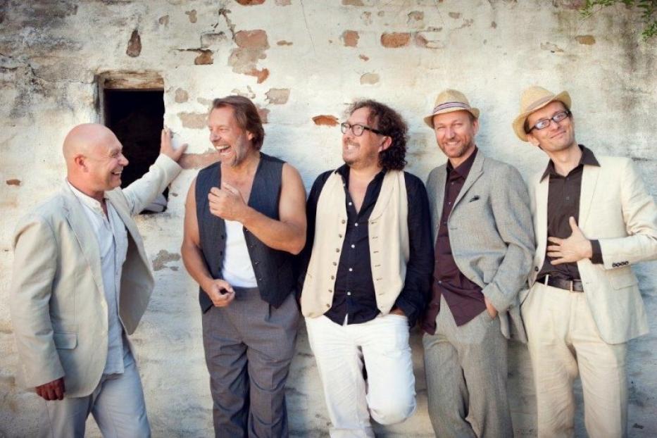 Die Jimmy Schlager Band posiert vor einer Wand.