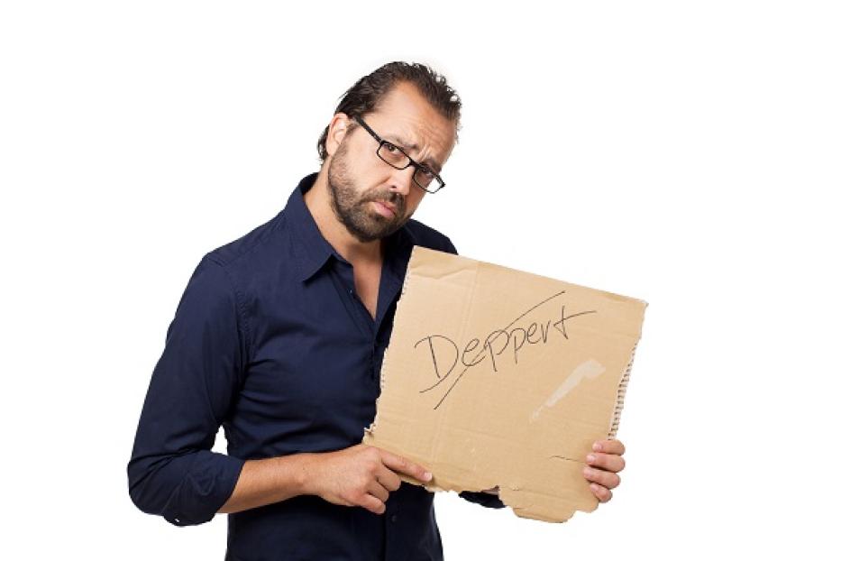 Ein Mann hält ein Pappschild mit der Aufschrift „Deppert“.