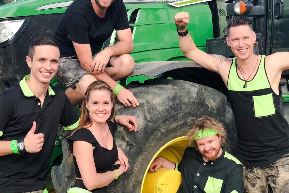 Die Band „Die Draufgänger“ posiert auf einem grünen Traktor für ein Foto.