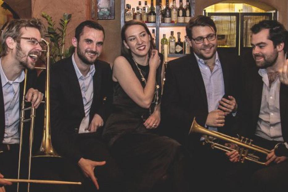 Die Coquette Jazzband posiert mit ihren Instrumenten in einer Bar.