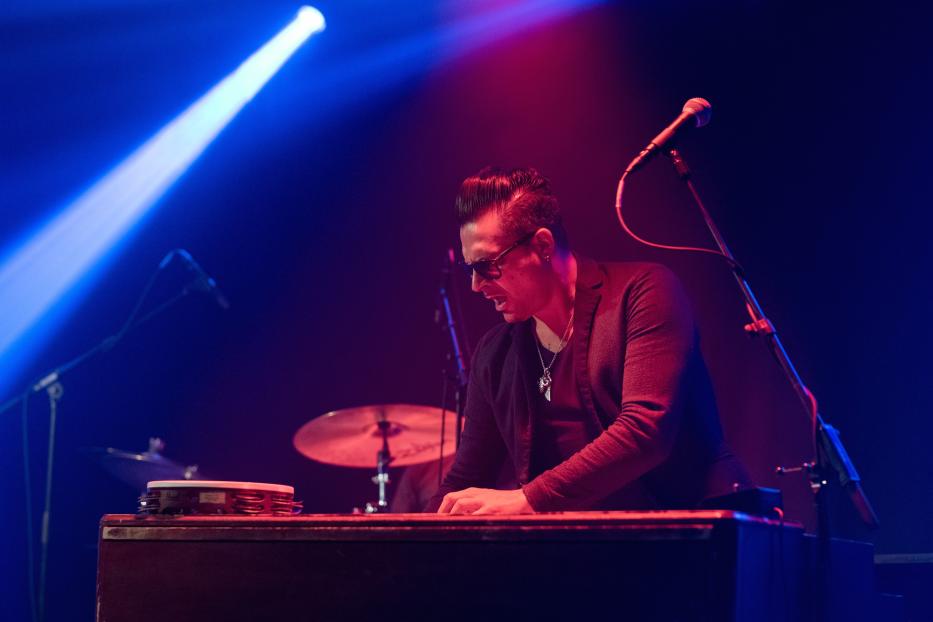 Raphael Wressnig spielt Keyboard auf einer Bühne mit blauem und rotem Licht.