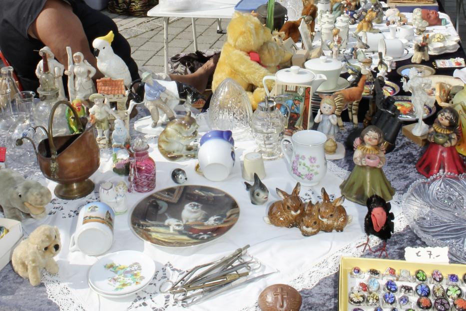 Verschiedene Antiquitäten und Sammlerstücke auf einem Tisch auf einem Markt in Neunkirchen.