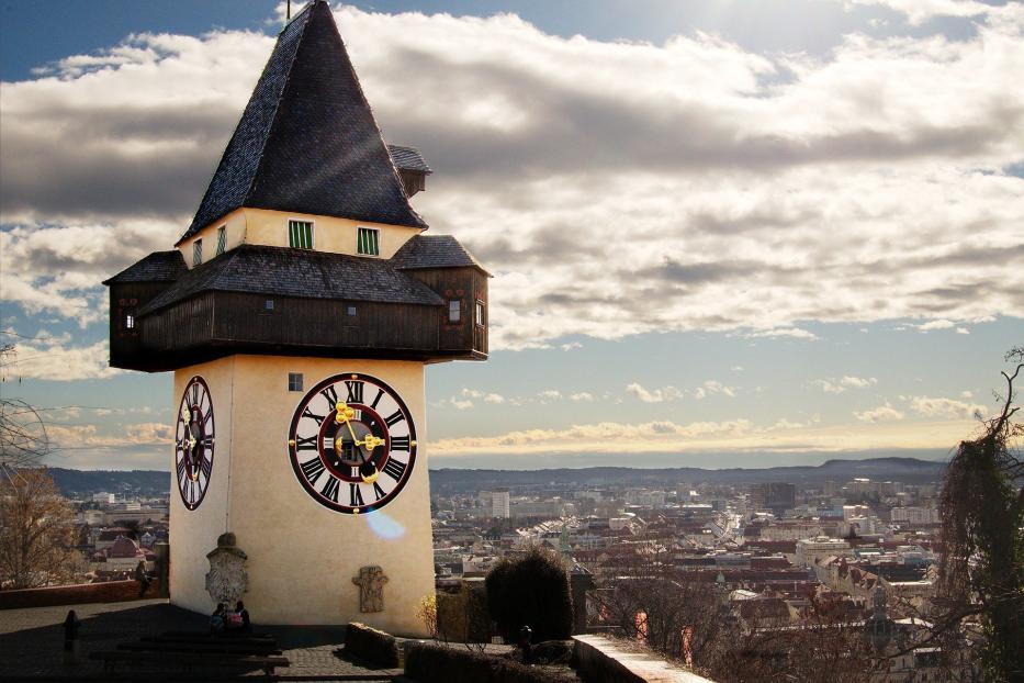 Der Grazer Uhrturm überblickt die Stadt an einem sonnigen Tag.