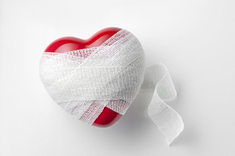 Ein rotes Plastikherz in einer Bandage