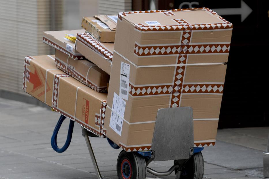 Ein Handwagen ist mit mehreren Paketen beladen.
