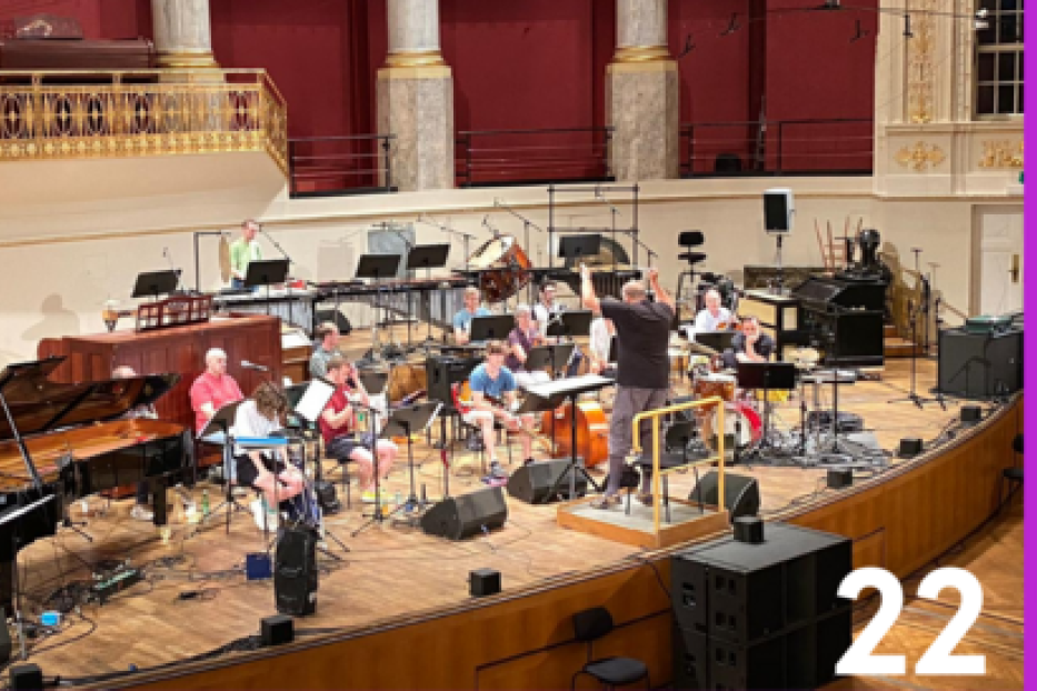 Ein Orchester probt auf einer Bühne in einem Konzertsaal.