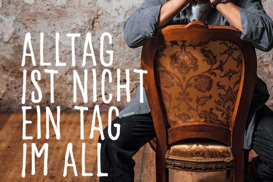 Das Buchcover von „Alltag ist nicht ein Tag im All“ mit Joesi Prokopetz auf einem Stuhl.