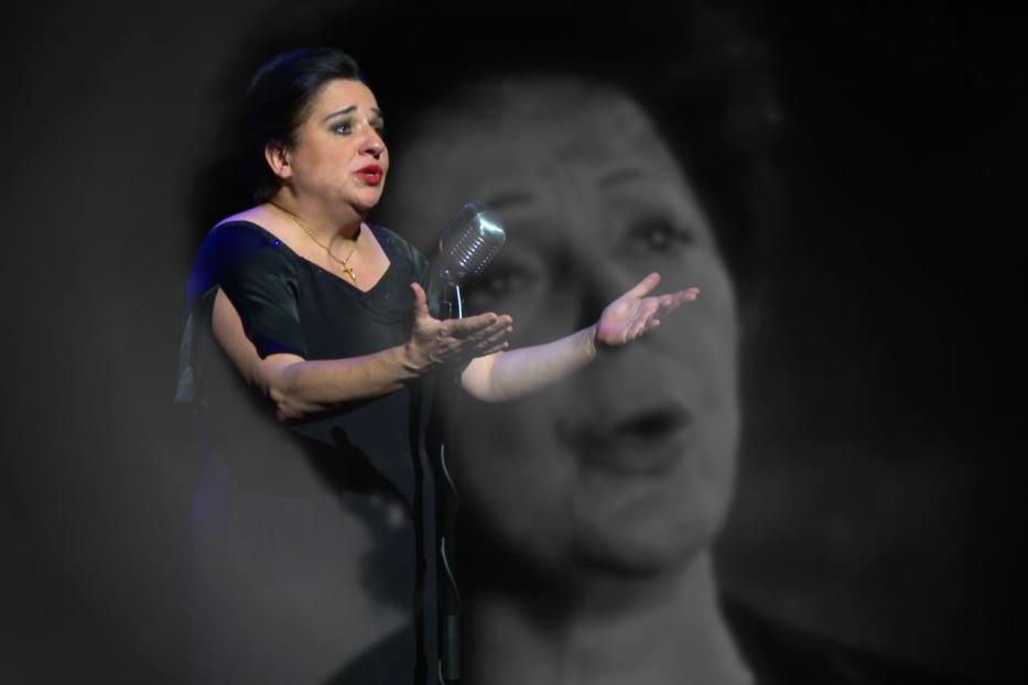 Eine Frau singt mit einem alten Mikrofon vor einem verschwommenen Hintergrund.
