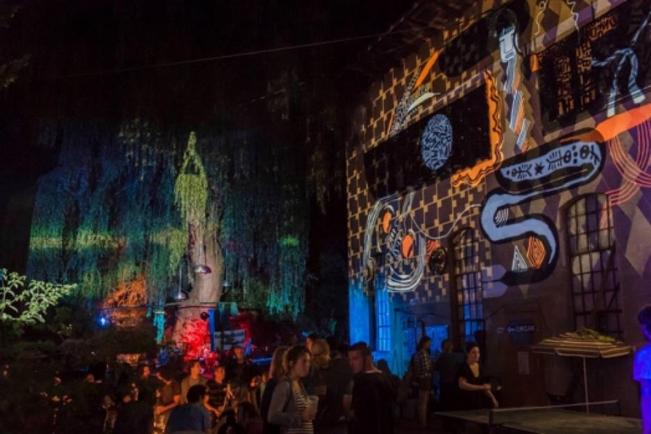 Eine Menschenmenge genießt eine Lichtprojektionsshow im Freien.