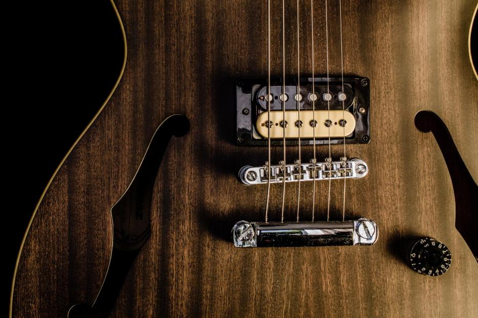 Detailaufnahme einer halbakustischen Gitarre mit braunem Holzkorpus.
