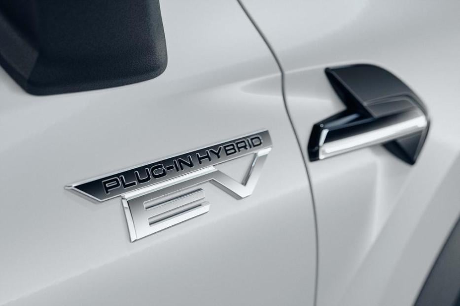 Das „Plug-in Hybrid EV“-Emblem an einem weißen Auto.