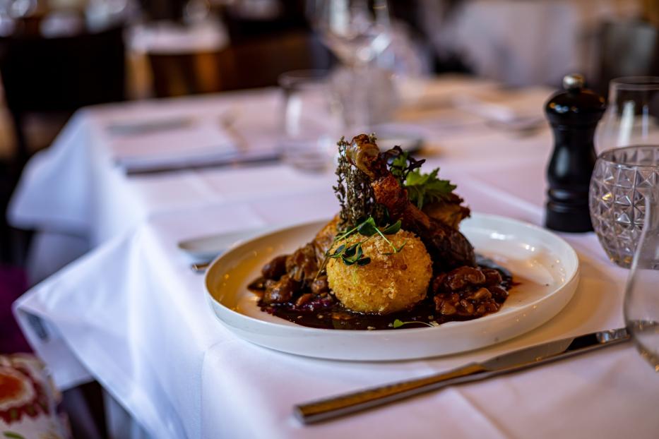 Eine vegane Gans mit Knödel und Beilagen, serviert in einem Restaurant.