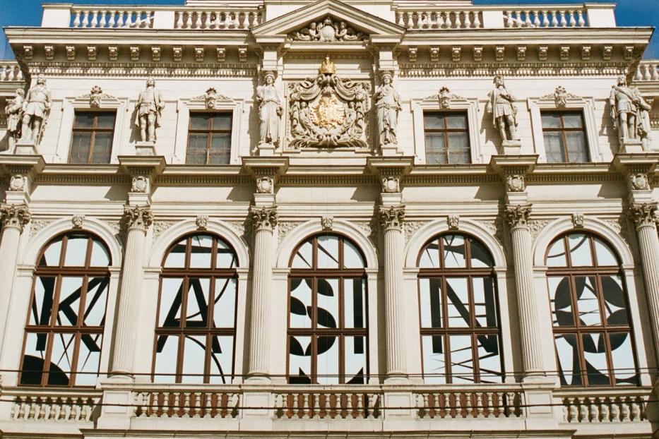 Die Fassade eines verzierten Gebäudes unter einem blauen Himmel.