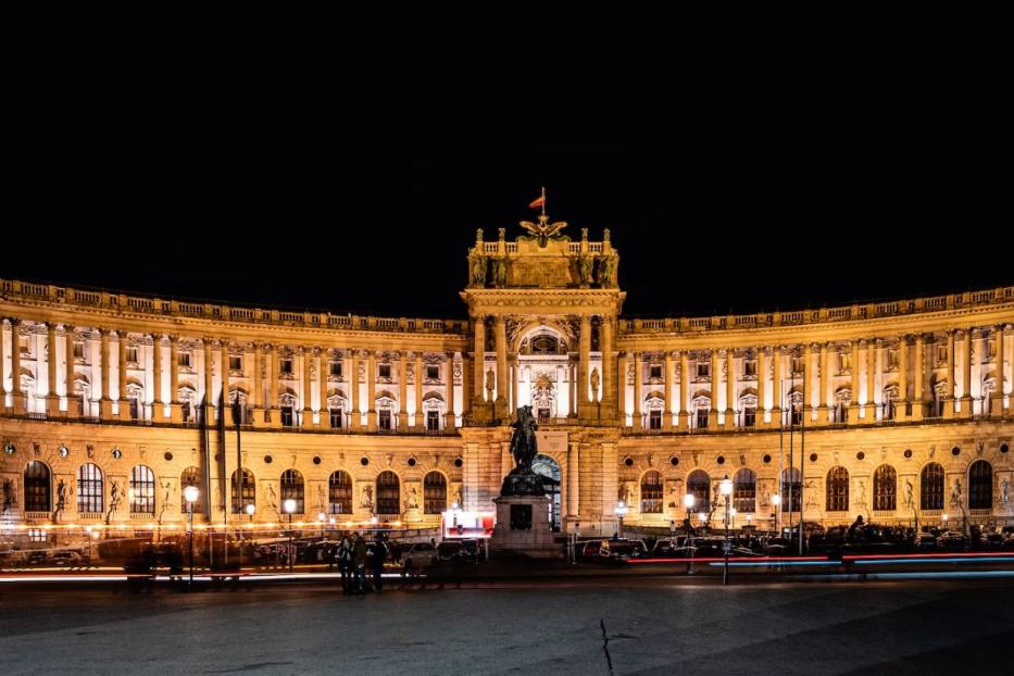 Die Hofburg in Wien ist nachts hell erleuchtet.