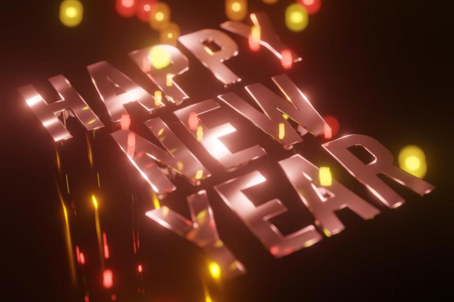Der Schriftzug „Happy New Year“ mit Lichtern im Hintergrund.