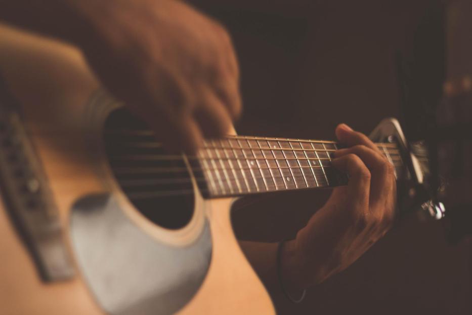 Jemand spielt auf einer akustischen Gitarre.