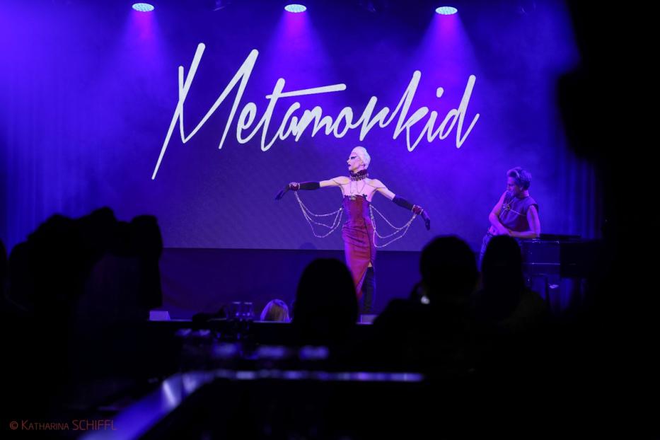 Eine Dragqueen namens Metamorkid tritt auf einer Bühne vor Publikum auf.