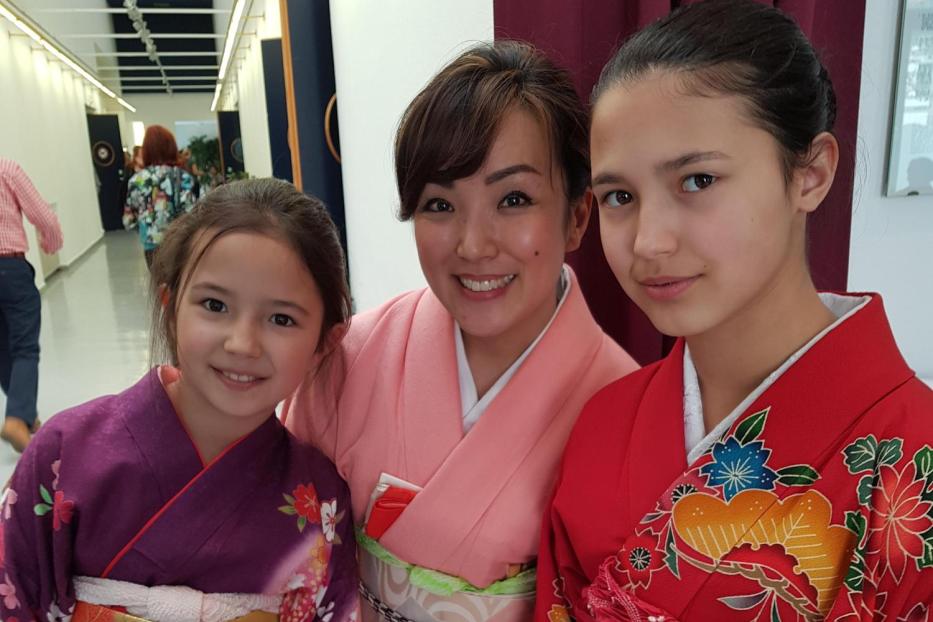Drei Frauen, gekleidet in traditionelle Kimonos, posieren für ein Foto.