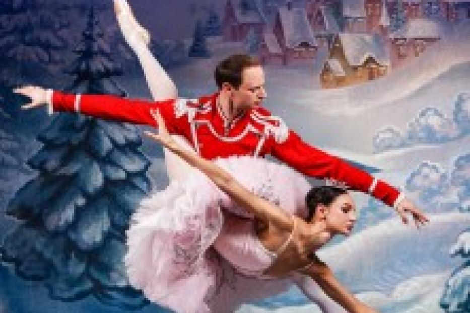 Zwei Balletttänzer führen eine anspruchsvolle Hebefigur vor einer Winterkulisse auf.