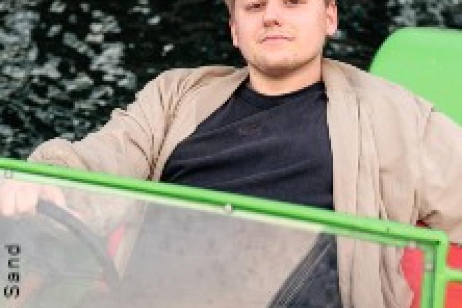 Ein junger Mann sitzt in einem Tretboot auf dem Wasser.