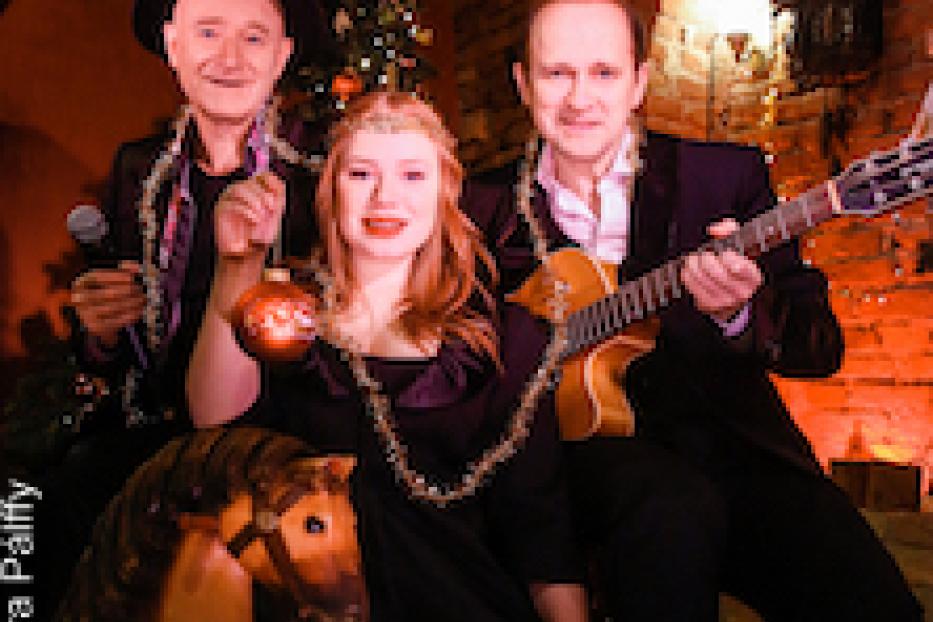 Eine Band posiert vor einem Weihnachtsbaum mit einem Steckenpferd im Vordergrund.