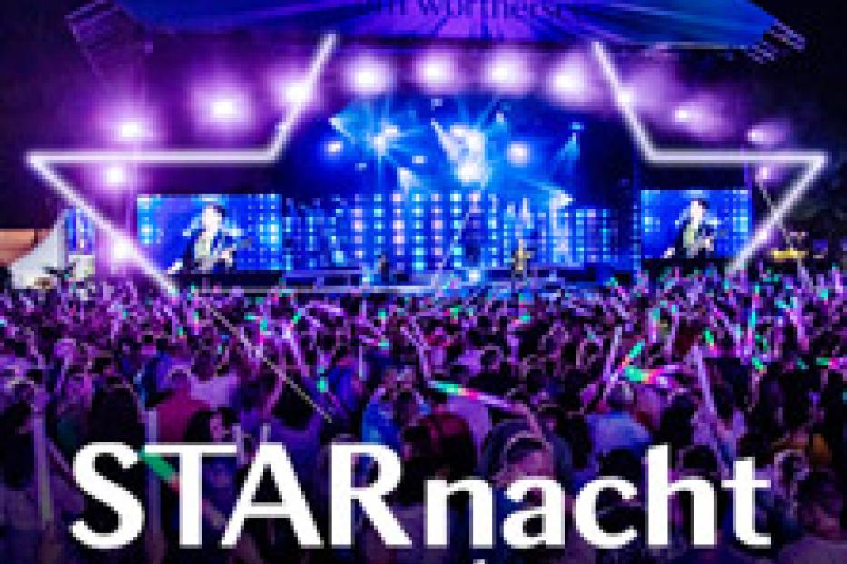 Eine Menschenmenge feiert bei der „STARnacht am Wörthersee“ vor einer Bühne mit Lichteffekten.