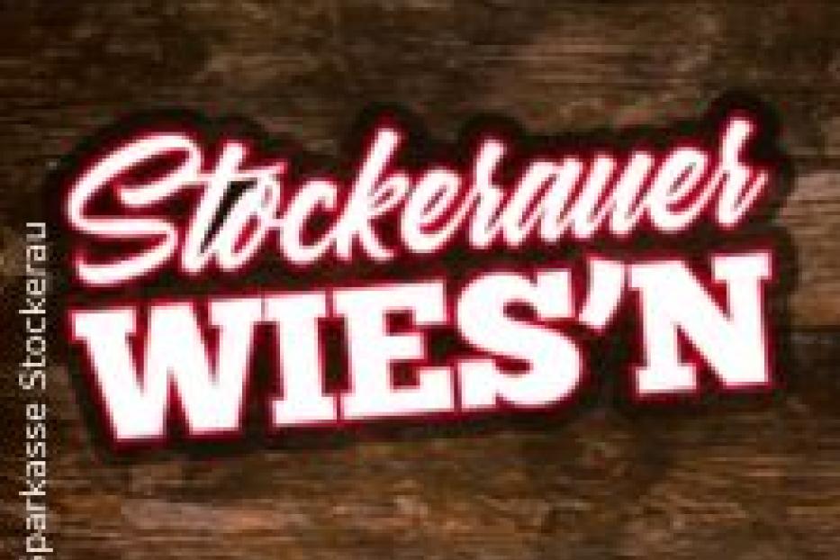 Das Logo für die Stockerauer Wies’n vor einem hölzernen Hintergrund.