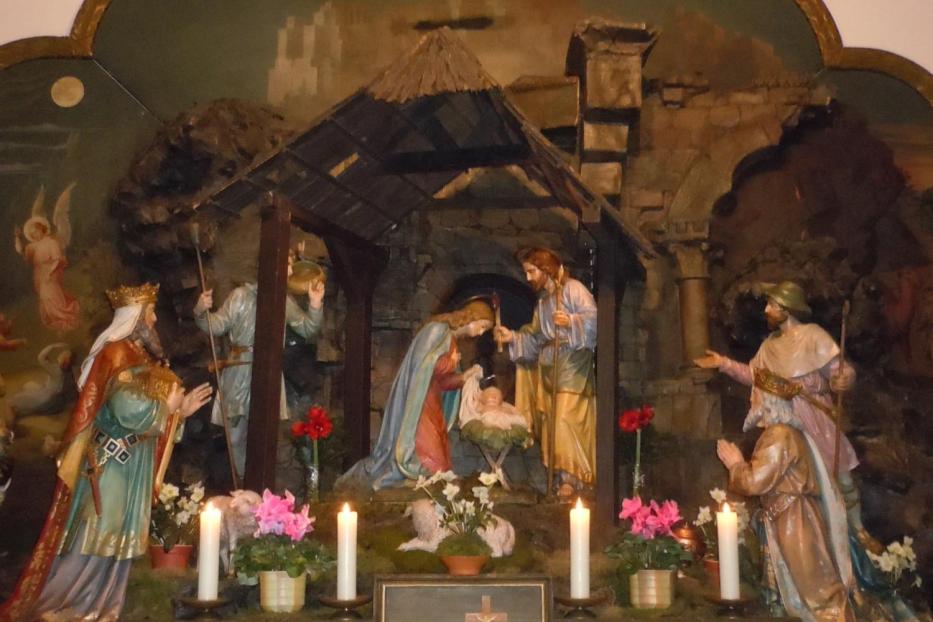 Eine Krippenszene mit Maria, Josef und dem Jesuskind in einer Holzhütte.