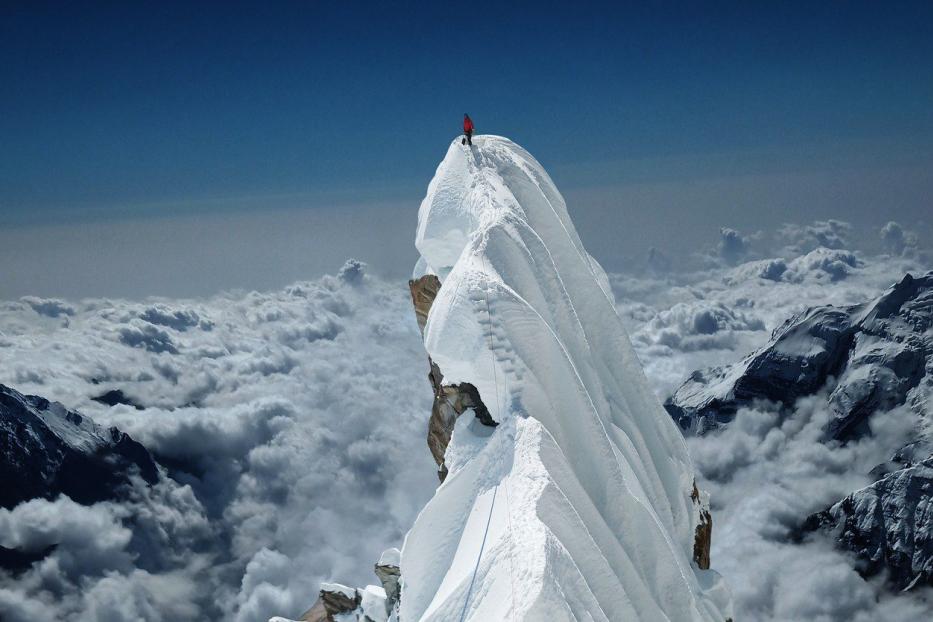 Ein Bergsteiger auf einer Bergspitze.