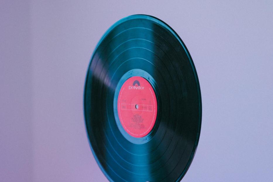 Eine Hand hält eine grüne Schallplatte des Labels Polydor.