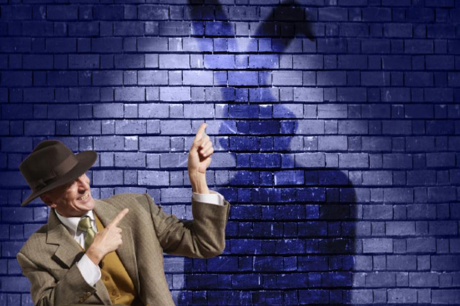 Ein Mann im Anzug deutet auf seinen Schatten, der wie ein Hase aussieht.