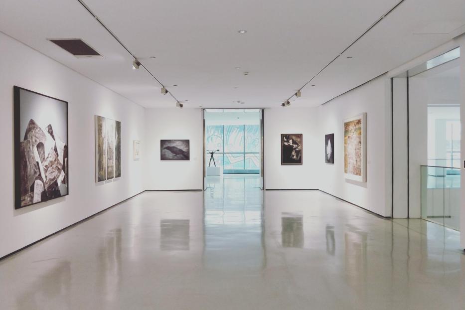 Ein leerer Ausstellungsraum mit Kunstwerken an den Wänden.