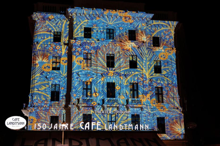 Das Café Landtmann in Wien ist mit floralen Mustern in Blau und Gelb beleuchtet.