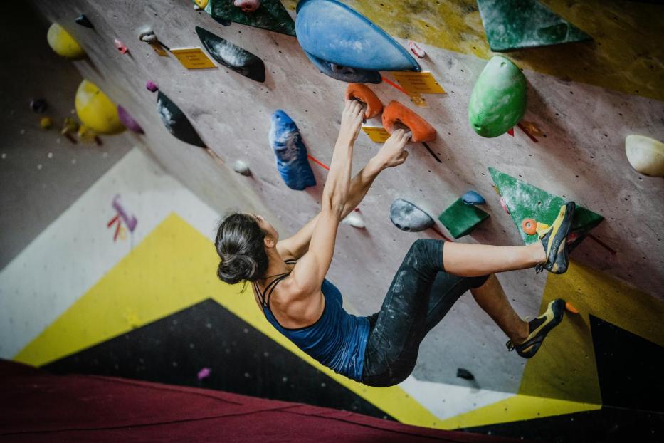 Eine Frau klettert auf einer Kletterwand.