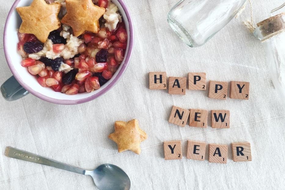 Ein Teller mit Keksen, eine Schüssel Müsli mit Sternen und die Worte „Happy New Year“.