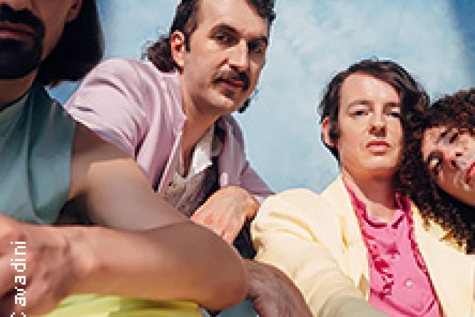 Die vier Bandmitglieder von Parcels posieren vor einem hellblauen Hintergrund.