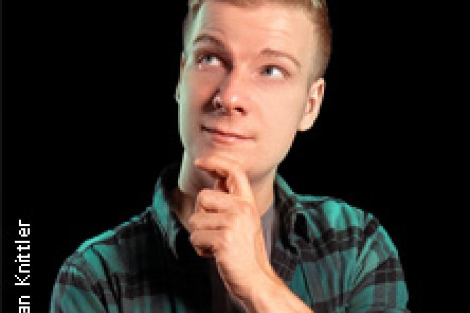 Ein junger Mann mit blonden Haaren schaut nachdenklich nach oben.