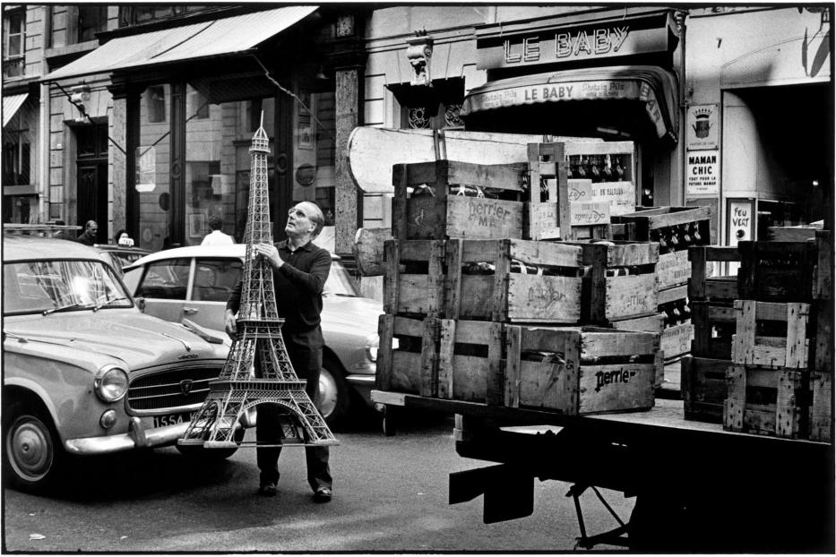 Ein Mann hält ein Modell des Eiffelturms in einer Straße in Paris.