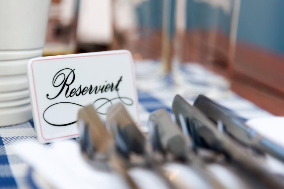 Ein Tisch mit einem „Reserviert“-Schild und Besteck.