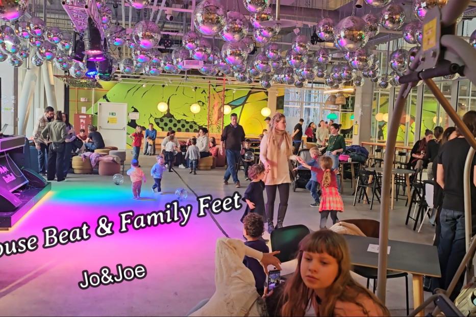 In einem Raum voller Discokugeln tanzen Kinder und Erwachsene.