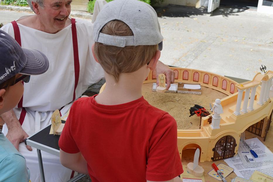 Kinder spielen mit einem Modell des Kolosseums im Stadtmuseum Tulln.