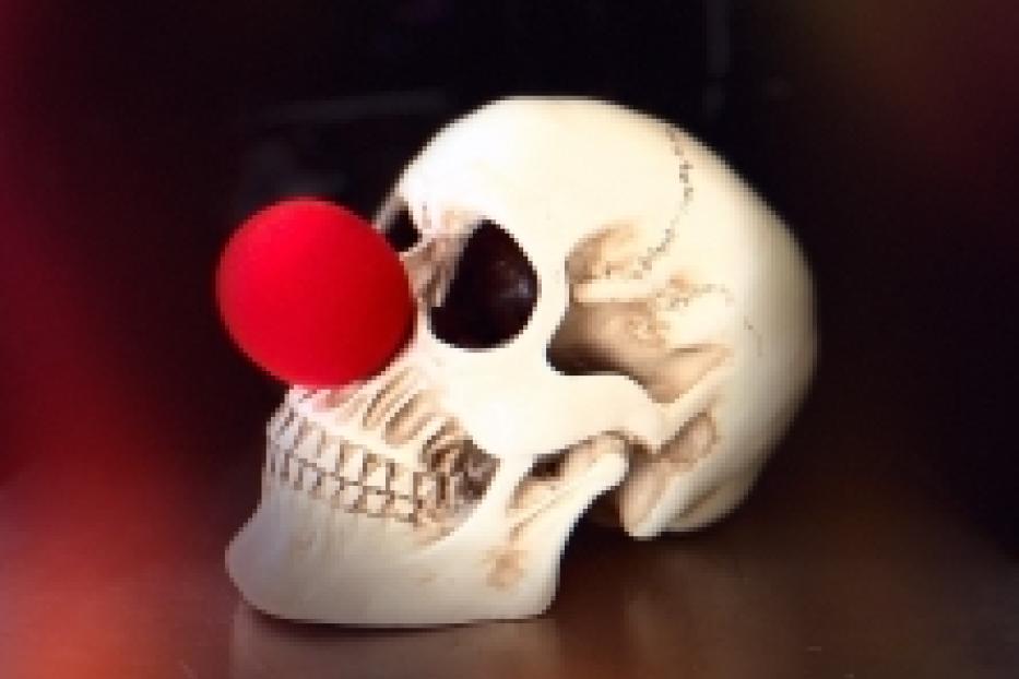 Ein Schädel trägt eine rote Clownsnase.
