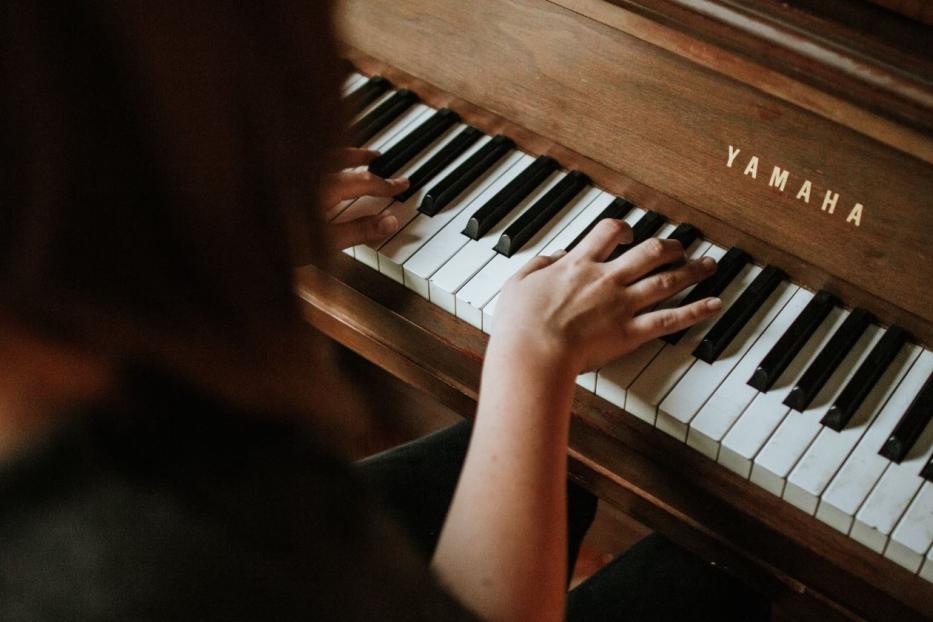 Eine Person spielt auf einem Yamaha-Klavier.