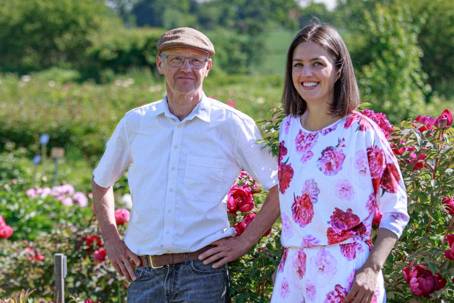 Ein Mann und eine Frau stehen in „Mielys Pfingstrosengarten“.