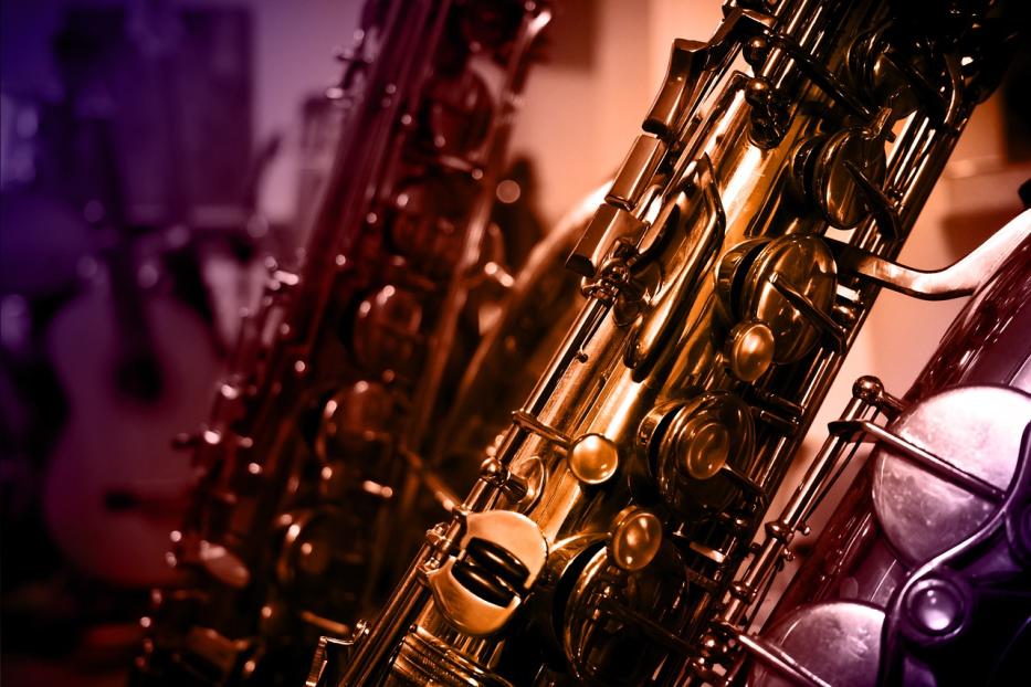 Nahaufnahme von mehreren Saxophonen in warmen Farbtönen.