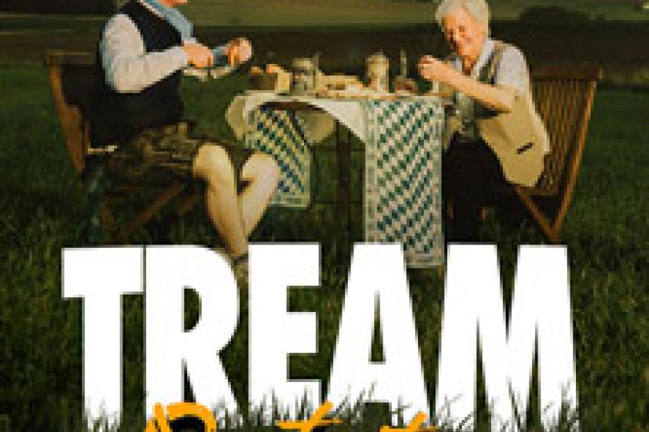 Ein junger Mann und eine ältere Frau sitzen an einem Tisch im Grünen und machen Brotzeit.