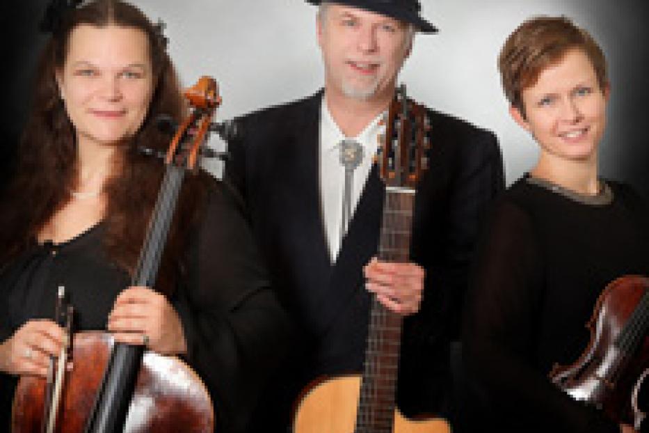 Ein Trio, bestehend aus zwei Frauen und einem Mann, posiert mit ihren Musikinstrumenten.
