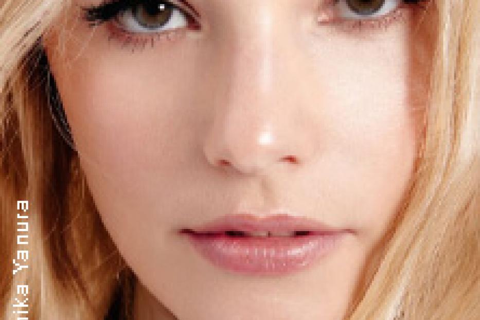 Nahaufnahme des Gesichts einer jungen Frau mit blonden Haaren und hellen Augen.